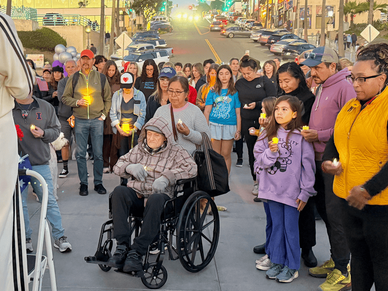A solemn and peaceful crowd of about 200 people gathered Sunday evening at the Manhattan Beach pier for a candlelight vigil called in support of "immigrant rights and democracy."