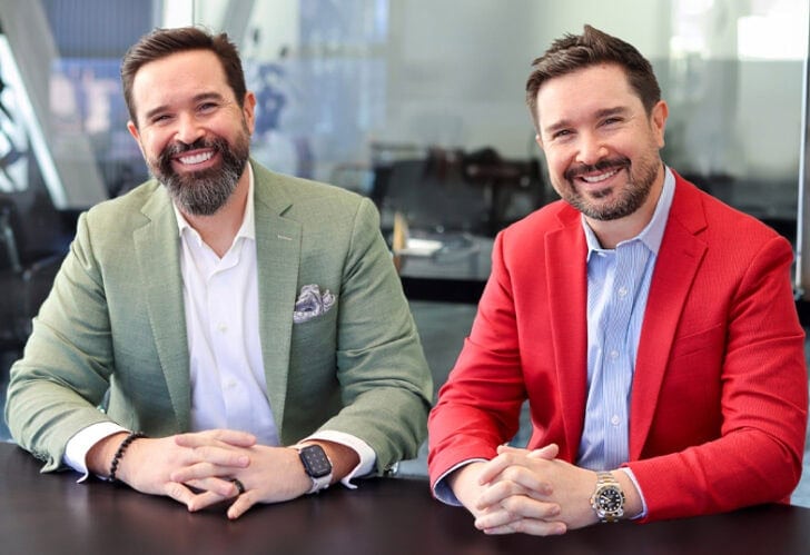 Brad Simon and Robert Simon, founding attorneys of The Simon Law Group, seated at a conference table in professional attire